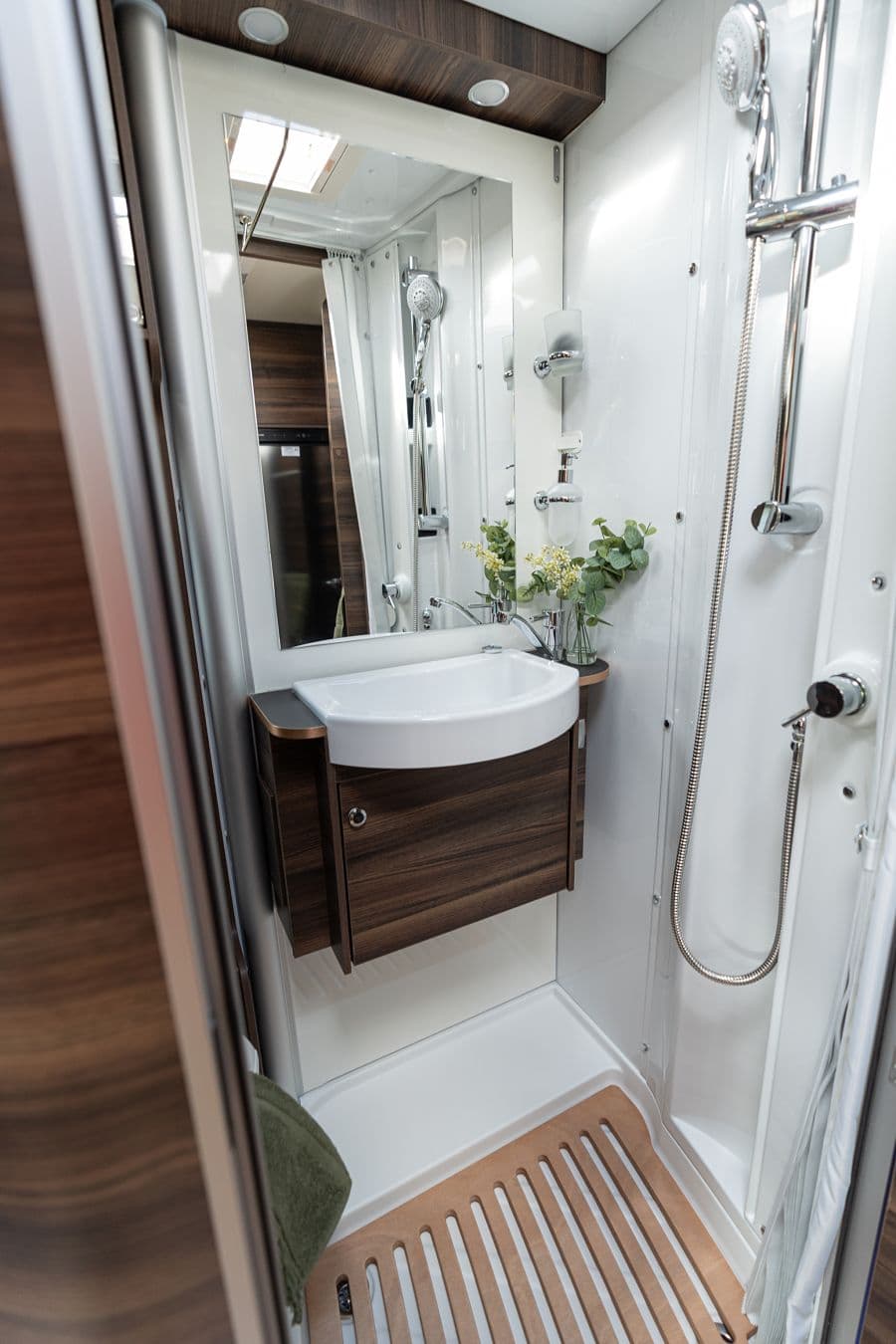 4-berth campervan onboard bathroom with sink, mirror and full shower