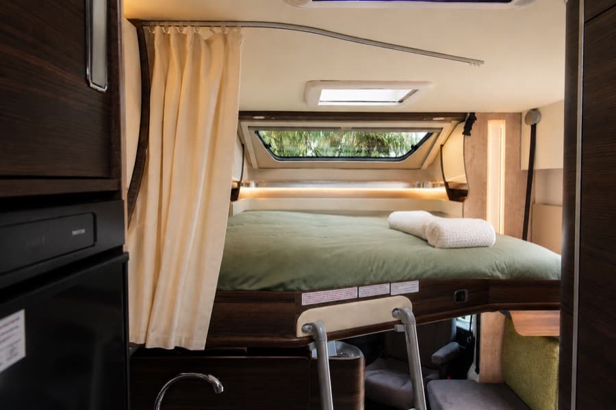 4-berth campervan electric drop-down front bed above the cab, lowered and made up