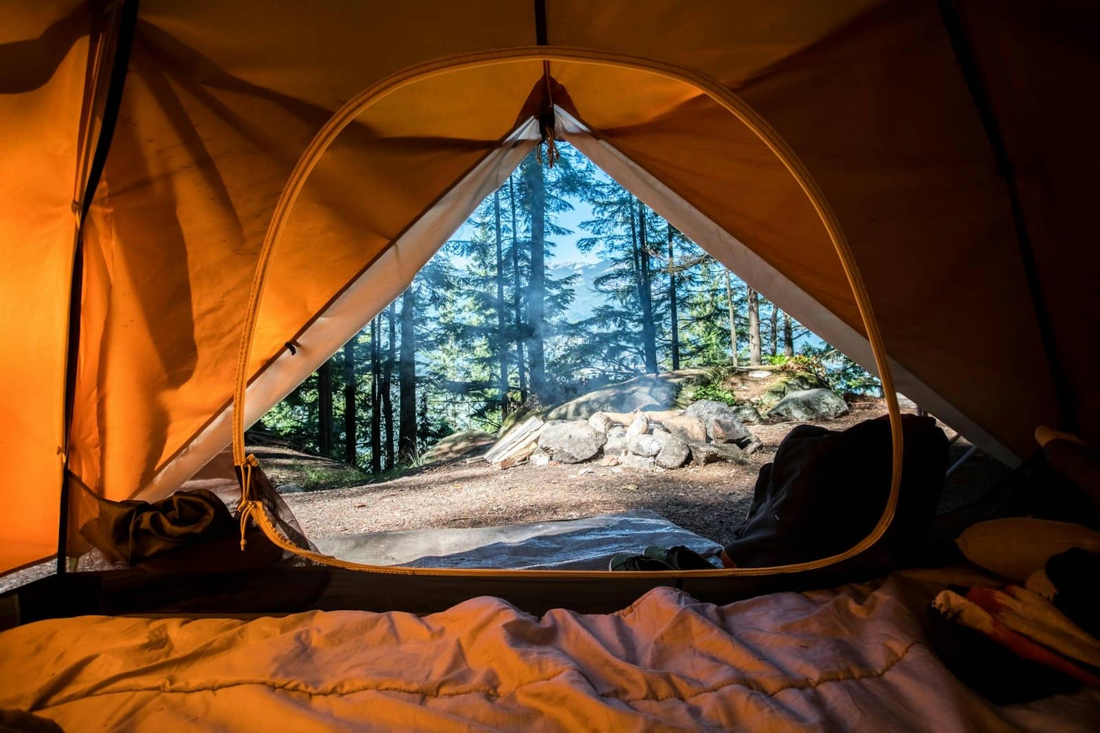 Campsite beside a New Zealand lake at golden hour with mountains in background