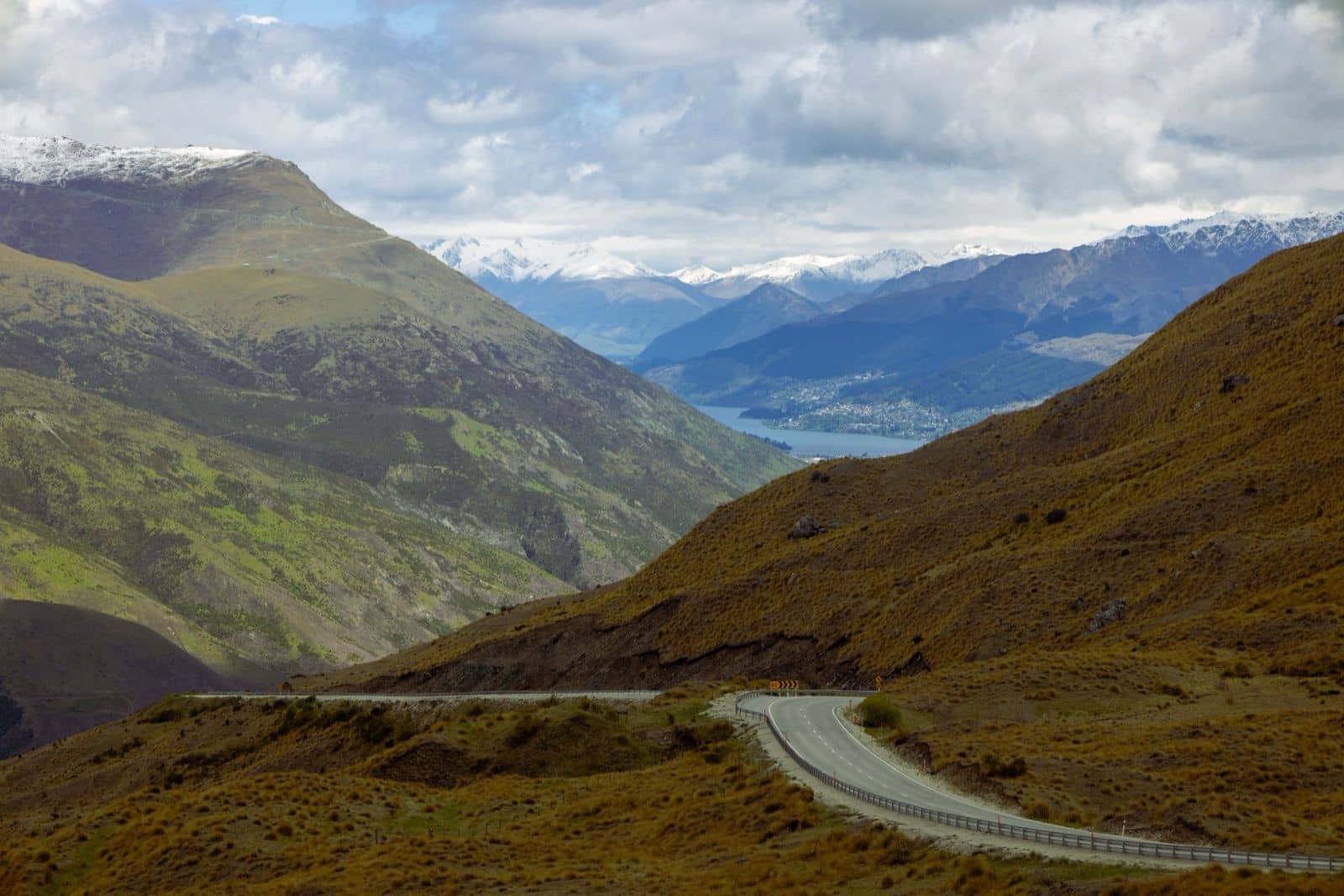 The Crown Range road descending towards Queenstown and Lake Wakatipu, the drive shared by campervan and rental car travellers in New Zealand