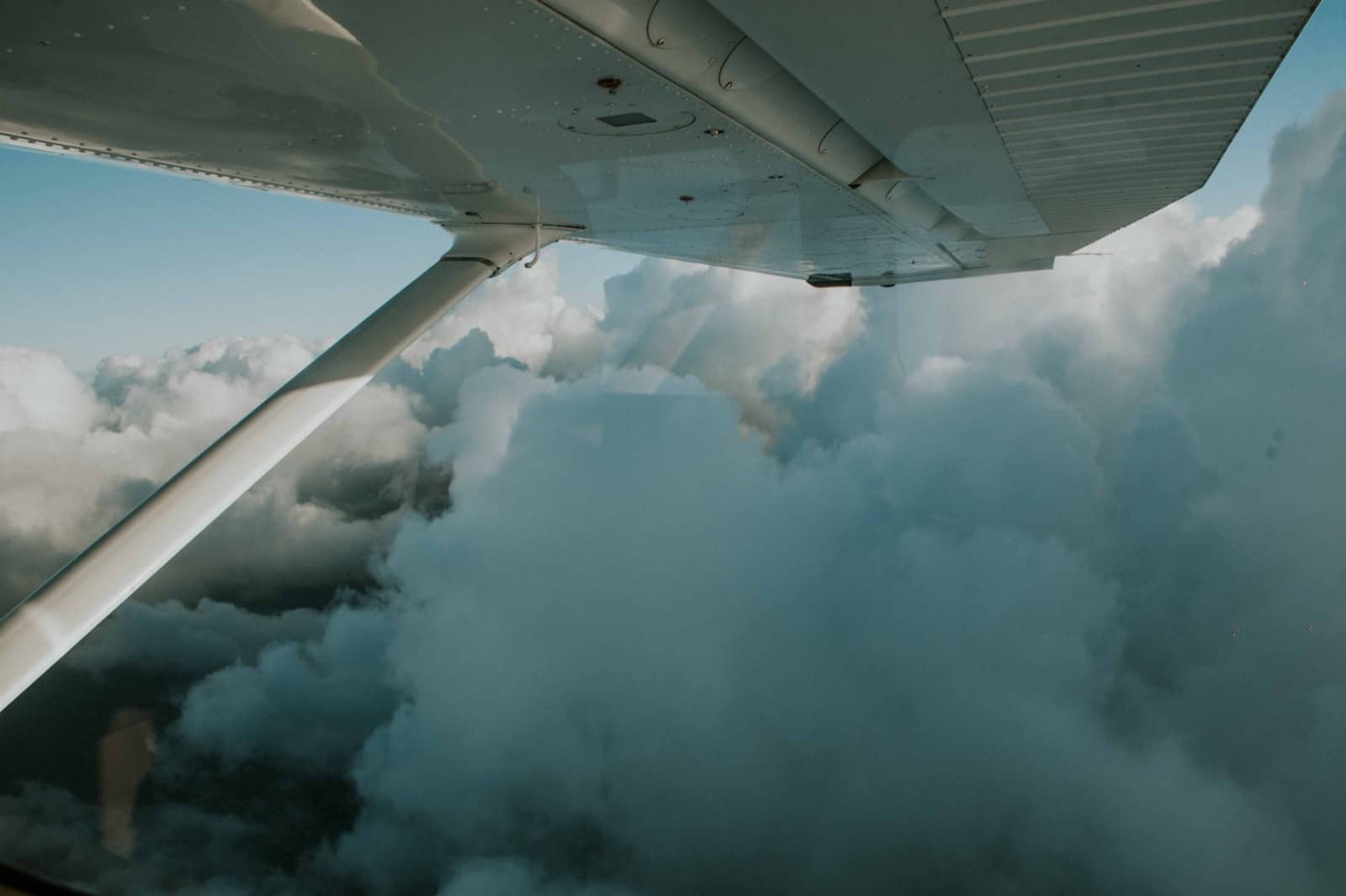 Blick aus dem Flugzeugfenster auf dichte Wolken auf dem Flug nach Neuseeland