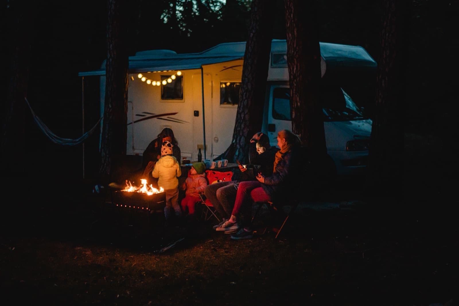 Kamperen bij een camper in de avond, waar een DOC-camping in Nieuw-Zeeland tussen niets en NZ$25 per persoon kost