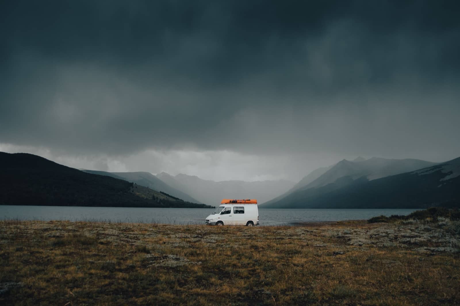 Camper bij een meer met bergen op de achtergrond tijdens een rondreis door Nieuw-Zeeland