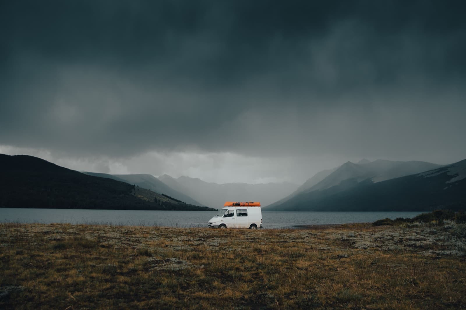 Camper bij een meer met bergen op de achtergrond tijdens een rondreis door Nieuw-Zeeland
