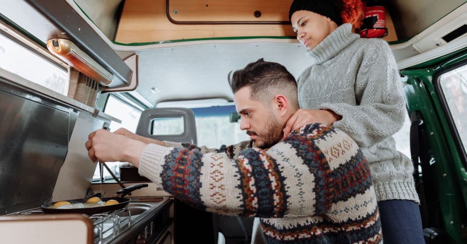 Stel kookt ontbijt in een gezellige camper